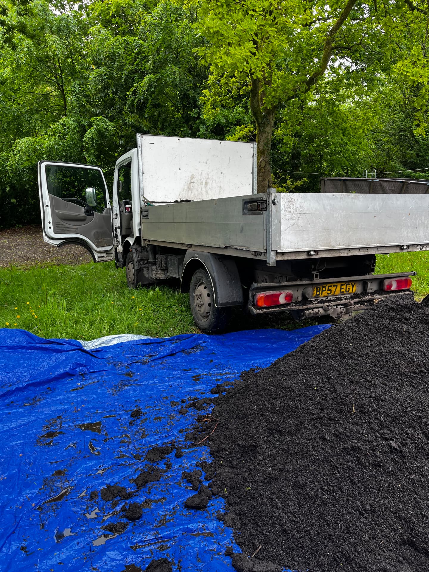 Tipper van unloading a 1,300 litre compost load onto a tarpaulin